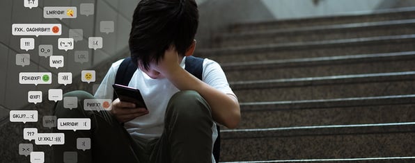 Boy sitting on the stairs, looking at a phone